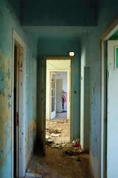 Peeling paint hallway and doors in abandoned building.