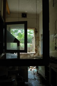 Window frames with broken glass in abandoned factory. Unrolled tape on the floor.