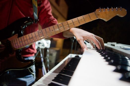 Close up image of musician with piano and guitar