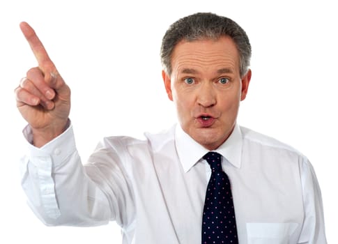 Businessman pointing up at copy space isolated over white background