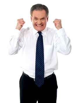 Angry senior corporate man standing with hs fists clenched against white background