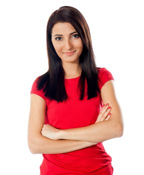 Pretty teenager posing with folded arms, smiling in front of camera