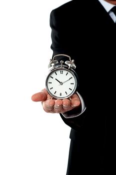 Cropped image of a man with alarm clock on his palm. Showing it to camera