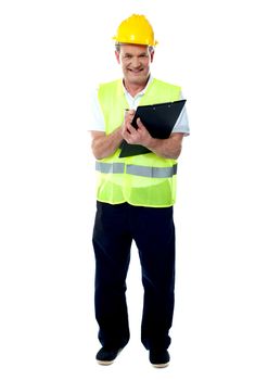 Full length portrait of an old age architect holding documents and writing something