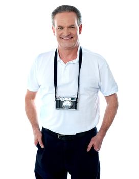 Mature cameraman posing smartly with hands in pocket. Camera around his neck