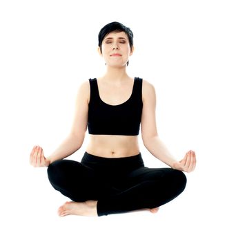 Portrait of young woman meditating in lotus pose