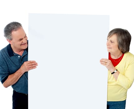 Old age couple presenting banner together against white background