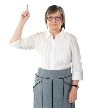 Beautiful senior business lady wearning eyeglasses and pointing upwards