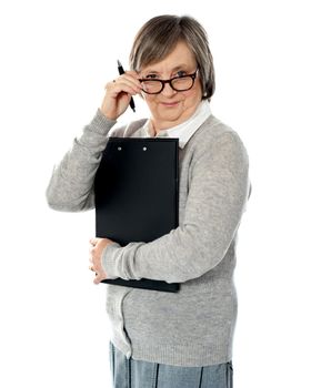 Corporate woman looking at you from within her eyeglasses. Carrying important papers