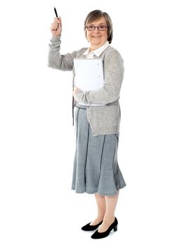 Lady with her notebook and pen in hand pointing up