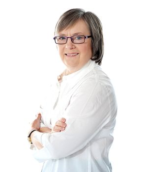 Side view of smiling senior female manager posing arms crossed