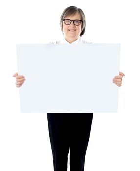 Senior businesswoman posing with blank placard. Showing it to camera