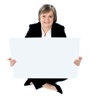 Corporate lady sitting on floor with a blank billboard isolated against white background