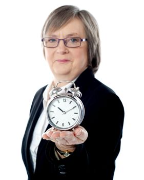 Female business executive showing alarm clock to camera
