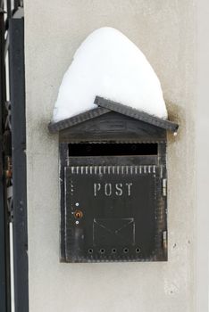 vintage black mail box covered by snow on gray background outdoor