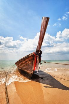 Old wooden traditional boat on the tropical beach - Thailand