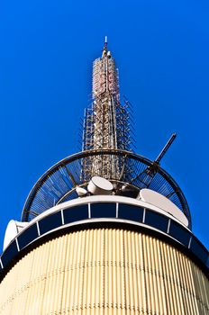 Telecom tower with microwave links and cellular network antennas on blue sky Oslo Norway