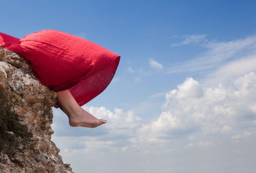 Girl sitting on the edge of a mountain