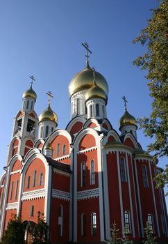 Church orthodox with the overgilded domes under the dark blue sky