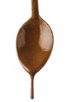 Chocolate dripping from spoon on white background.