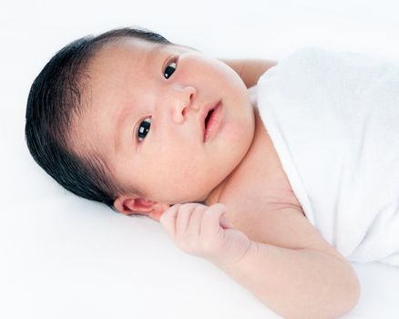 Portrait of a cute newborn baby lying on back over white background.