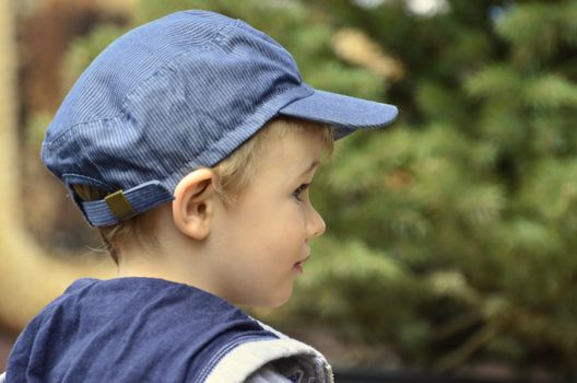 The picture shows a little boy who who looks curiously at the world.