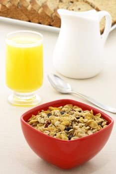 delicious breakfast with orange juice, whole grain bread,milk and a healthy bowl of cereal.