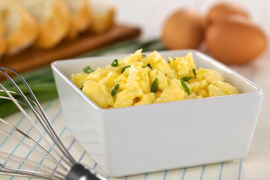 Scrambled eggs with green onion in bowl with beater on the side (Selective Focus, Focus one third into the bowl) 