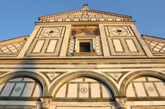 Facade of San Miniato al Monte in Florence, warm sunset light shot.