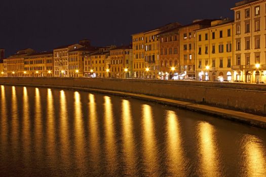 Pisa Riverside Night View with bright reflections over river Arno.