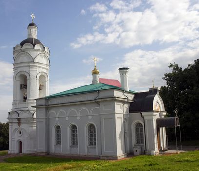 Orthodox white church, with a bell, the overgilded domes and crosses