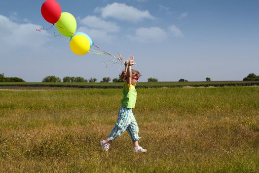 little girl running with balloons