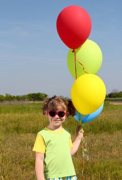 little girl with colorful balloons posing