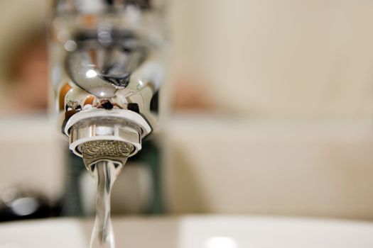 Close up frontal image of tap and water