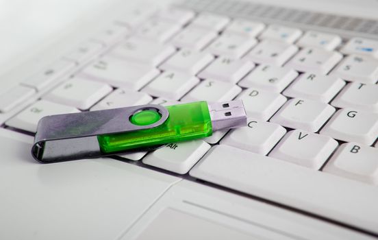 Close up image of laptop and green usb memory stick