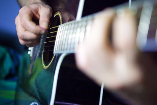 Close up image of acoustic guitar player