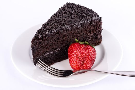 Chocolate cake on the table with strawberries and chocolate.