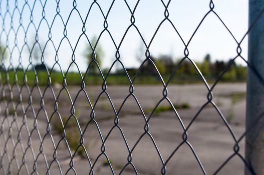a wire mesh in front of a large abandoned area