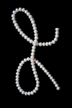 White pearls on the black velvet background 