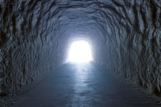 Inside a tunnel inside a mountain with light at the end