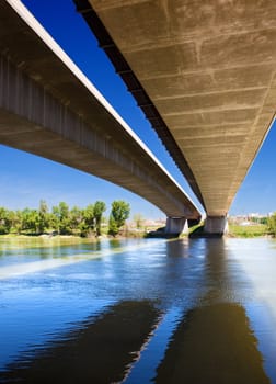 Close up image of under a bridge with a river