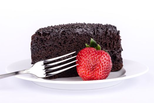 Chocolate cake on the table with strawberries and chocolate.