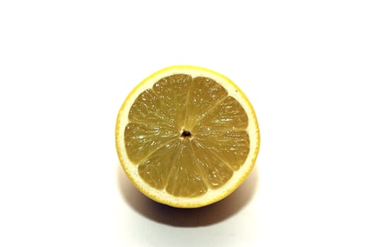 Half a cut lemon (centered) with segments visible against a white background with copy space