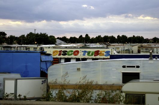 View across a crowded caravan site, with a colourful 'disco' van in the middle, against a cloudy sky with copy space.







View across a caravan site