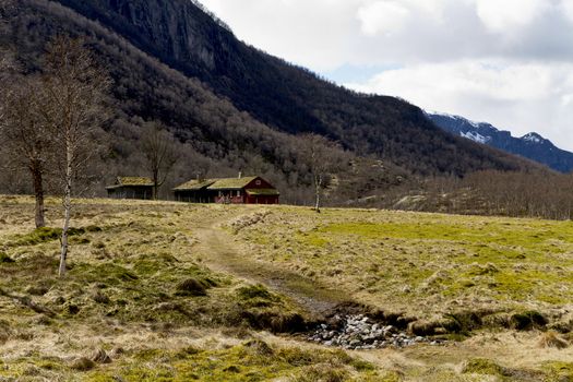 house in rural landscape with mountains in background. norway