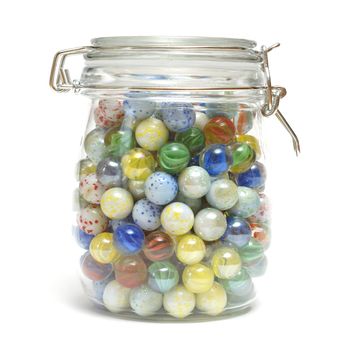 A glass jar is full of various marbles.