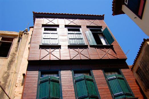 wooden color house and old windows with shutters