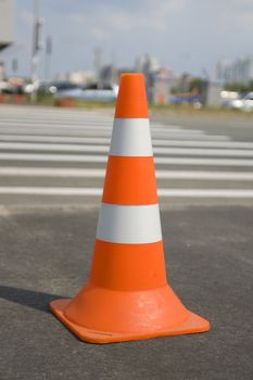 Close up of one traffic cone on a road with path