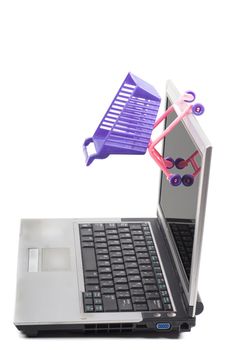 Laptop with a shopping-cart isolated on white