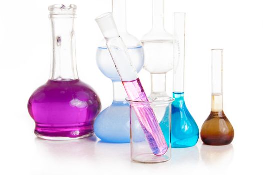 Test tubes and flasks with colorful liquids on white